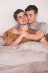 65787840-portrait-of-an-affectionate-young-gay-couple-lying-arm-in-arm-together-in-bed-in-the-...jpg