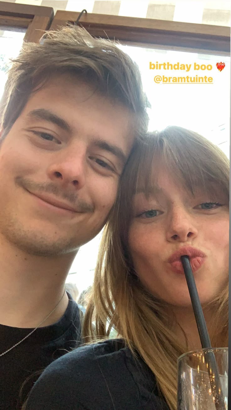 This may contain: a man and woman pose for a photo with a straw in their mouth while smiling at the camera