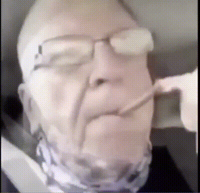 a man with glasses and a scarf around his neck is smoking a cigarette