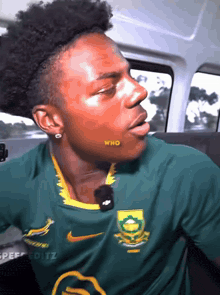 a man wearing a green nike shirt with the word who on his cheek