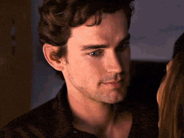 a close up of a man 's face looking at a woman