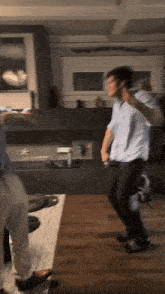 a man dancing in a living room with a fireplace in the background