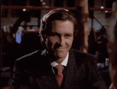 a man in a suit and tie is smiling and looking at the camera