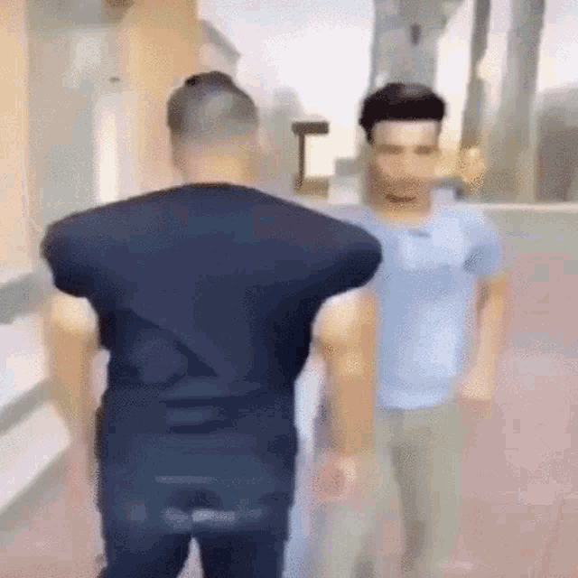 a man in a black shirt is standing next to a man in a blue shirt