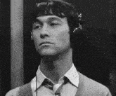 a man wearing headphones and a tie is listening to music .