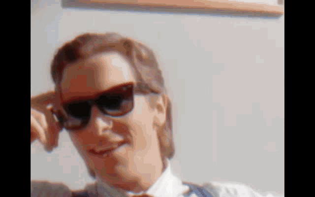 a close up of a man wearing sunglasses and smiling .