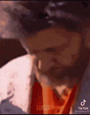 a close up of a man 's face with a tiktok watermark on the bottom