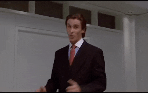 a man in a suit and tie is giving a thumbs up while standing in a room .