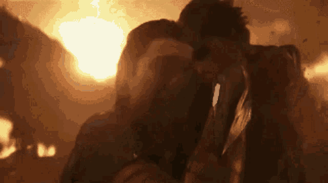 a man is holding a sword in front of a fire .