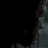 a person is looking out a window at a beach with boats in the distance .