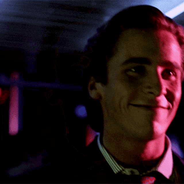 a close up of a man 's face with red light behind him