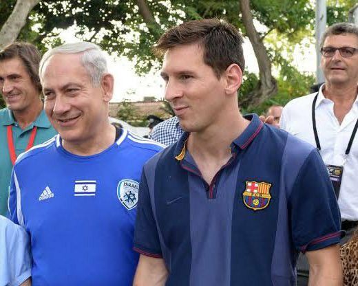 This may contain: two men are standing next to each other in front of some people and one is wearing a blue shirt
