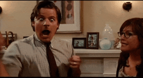 a man and a woman are standing next to each other in a room