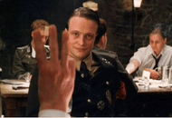 a man in a military uniform is waving his hand in a restaurant