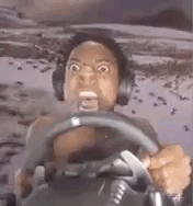 a man wearing headphones is driving a car while holding a steering wheel .