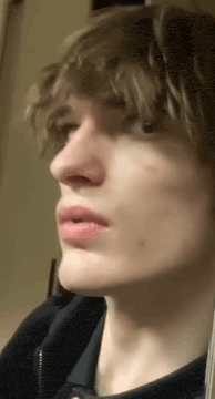 a close up of a young man 's face with a pink lip .