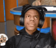 a man wearing headphones and a hat is sitting at a table
