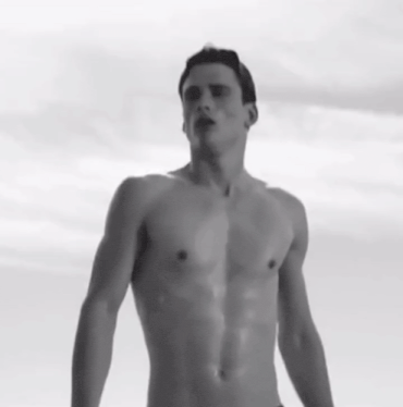 a shirtless man is standing in front of a cloudy sky