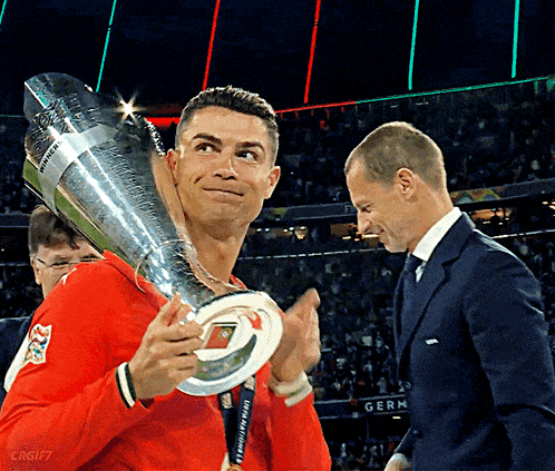 a man holding a trophy that says uefa champions league
