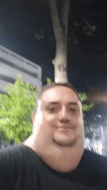 a man with a tree growing out of his head looks at the camera