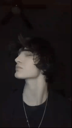 a young man with his eyes closed and his tongue hanging out .