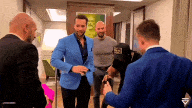 a group of men are standing in a room and one of them is wearing a hat that says dc on it