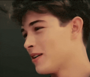 a close up of a young man 's face with his mouth open and his eyes closed .