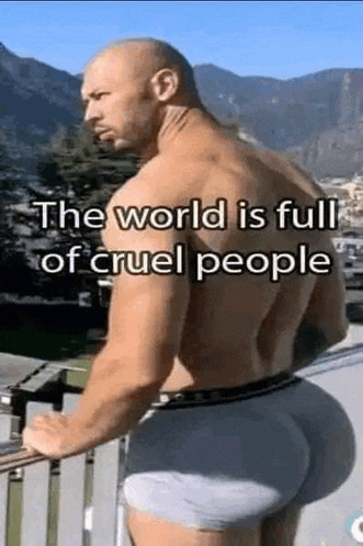 a man with a big butt is standing on a balcony with mountains in the background .