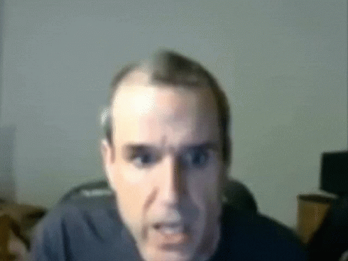 a blurry picture of a man 's face looking at the camera
