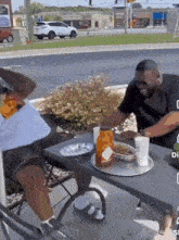 a man is sitting at a table with a tray of food on it