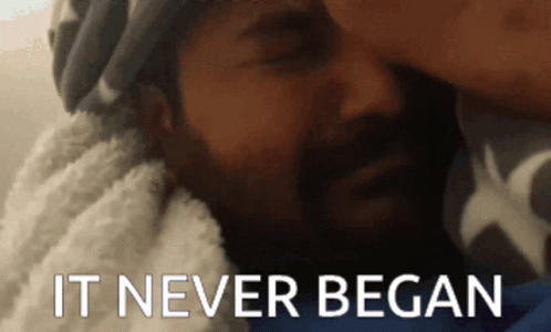 a man with a beard is laying on a bed with the words  it never began  written below him