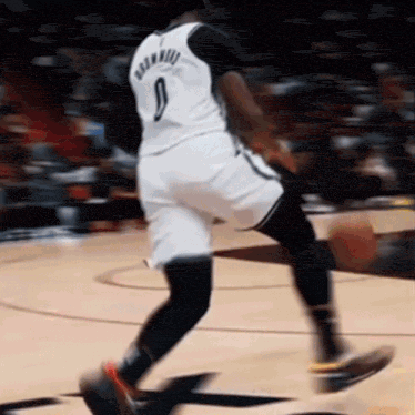 a basketball player wearing a number 9 jersey is dribbling the ball