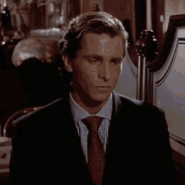 a man in a suit and tie is smiling in front of a mirror .