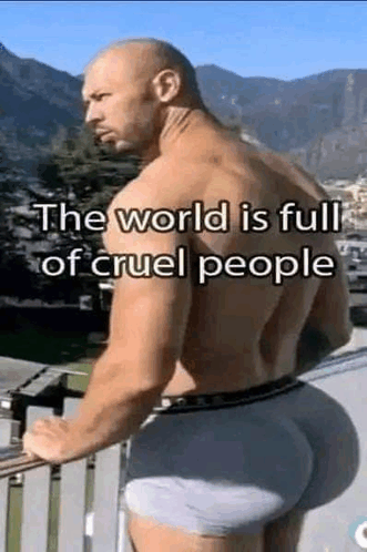 a man with a big butt is standing on a balcony with mountains in the background .