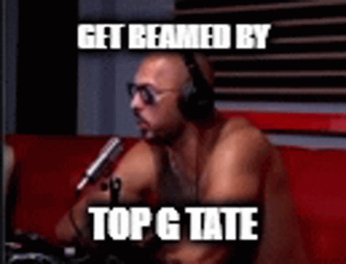 a shirtless man wearing headphones is sitting in front of a microphone with the caption get beamed by topg tate .