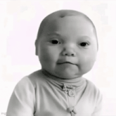 a baby is making a funny face in a black and white photo .