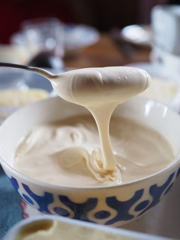 This may contain: a spoon full of cream sitting in a bowl